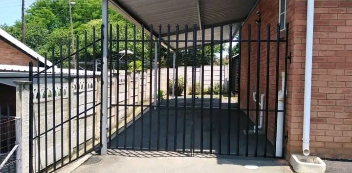 Steel-framed carport with a matching security gate