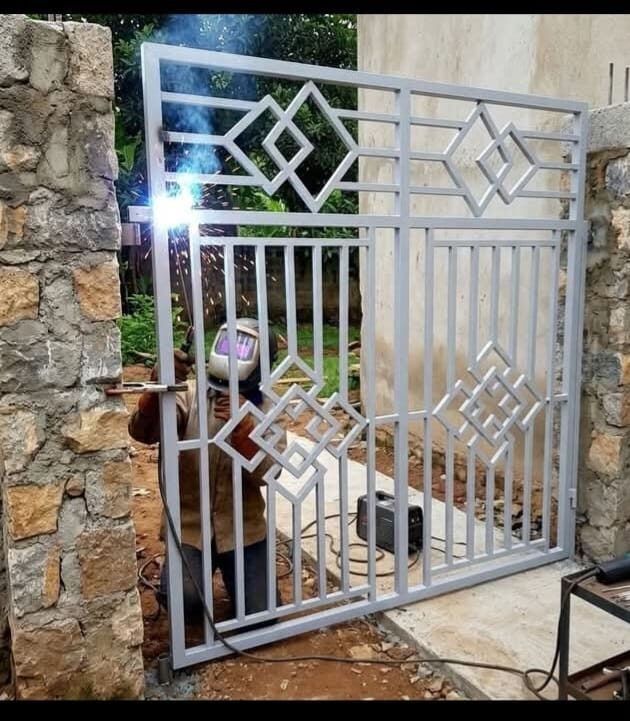 SN Welding Projects fabricator welding a custom diamond-pattern steel gate on site