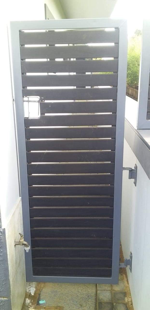 Slatted steel security door fitted over an outdoor utility area